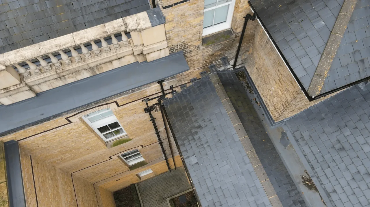 Aerial view of brick building elevations and adjoining roofs